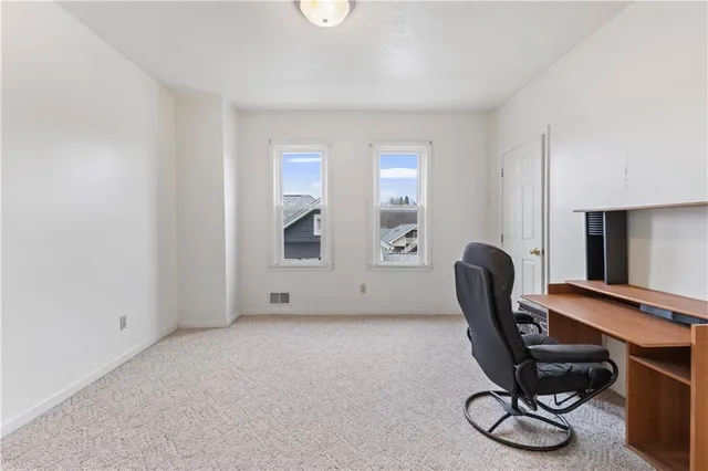 a view of workspace with lounge chair and windows