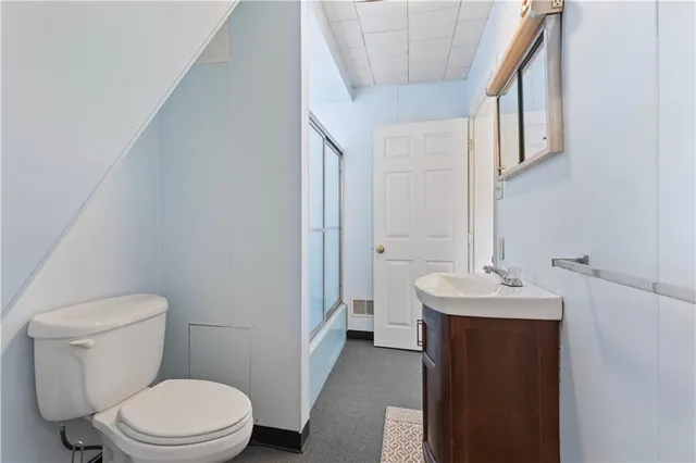 a bathroom with a sink a toilet and a mirror