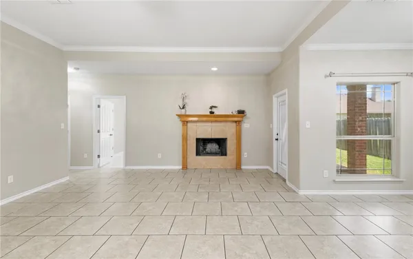 an empty room with windows and fireplace