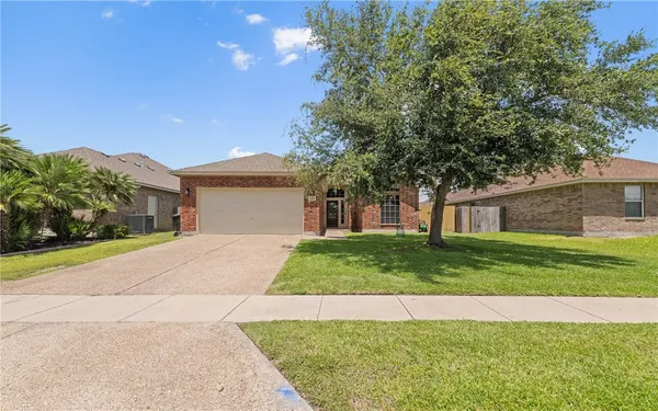 a front view of a house with a yard and a garage