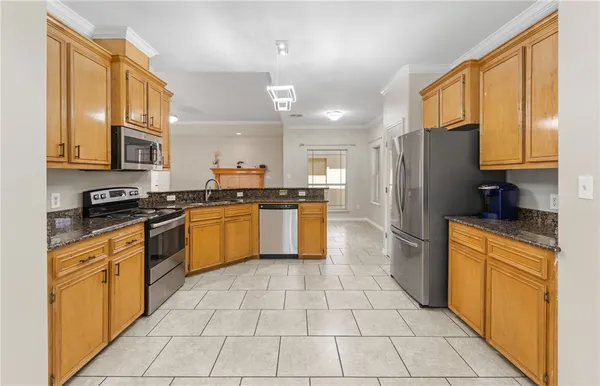 a kitchen with stainless steel appliances granite countertop a refrigerator and a stove top oven