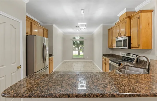 a kitchen with stainless steel appliances granite countertop a refrigerator stove and oven