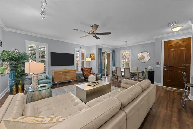 a living room with furniture chandelier and a flat screen tv