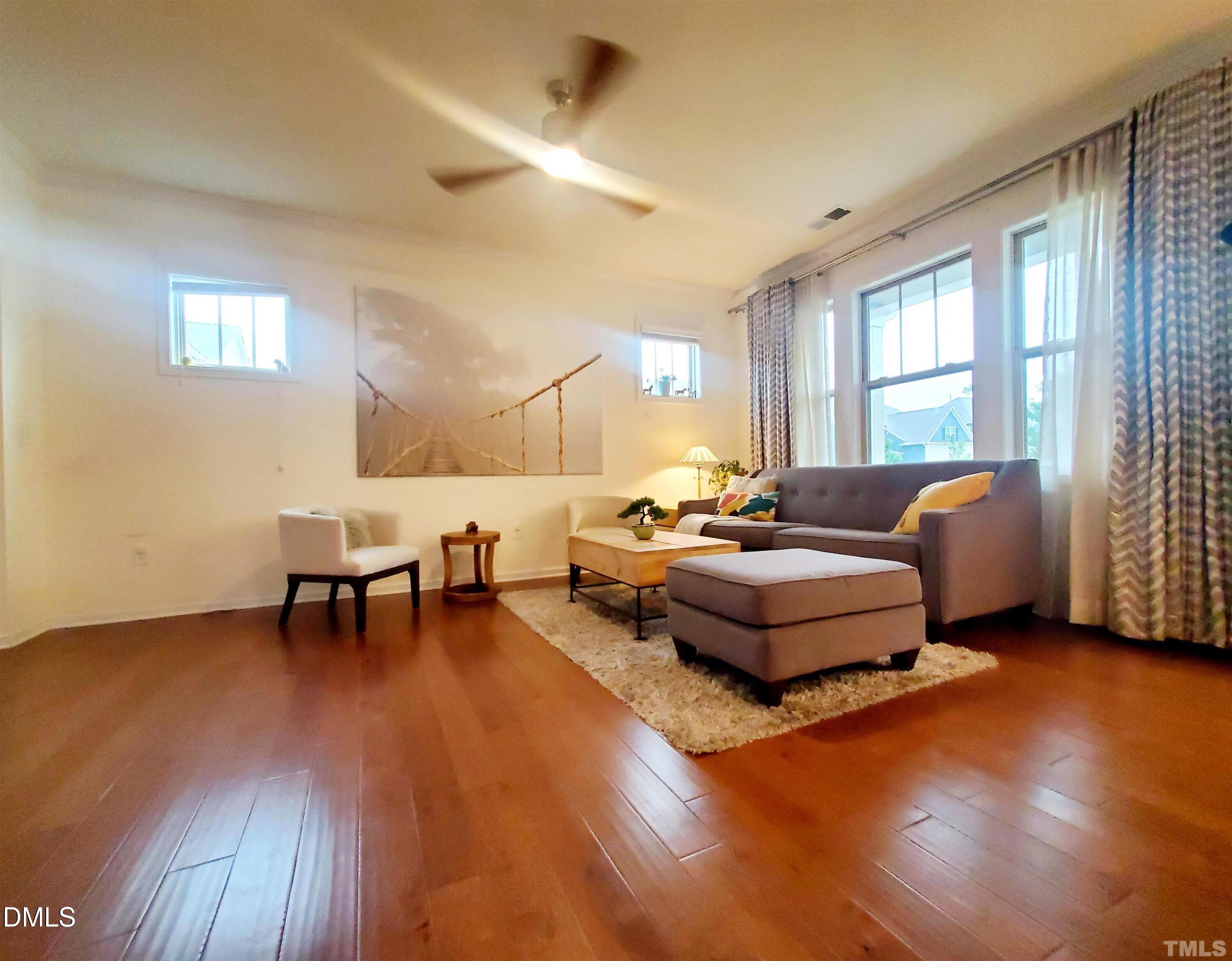 a living room with furniture and a wooden floor