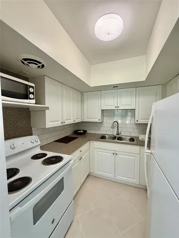 a kitchen with appliances a sink and cabinets