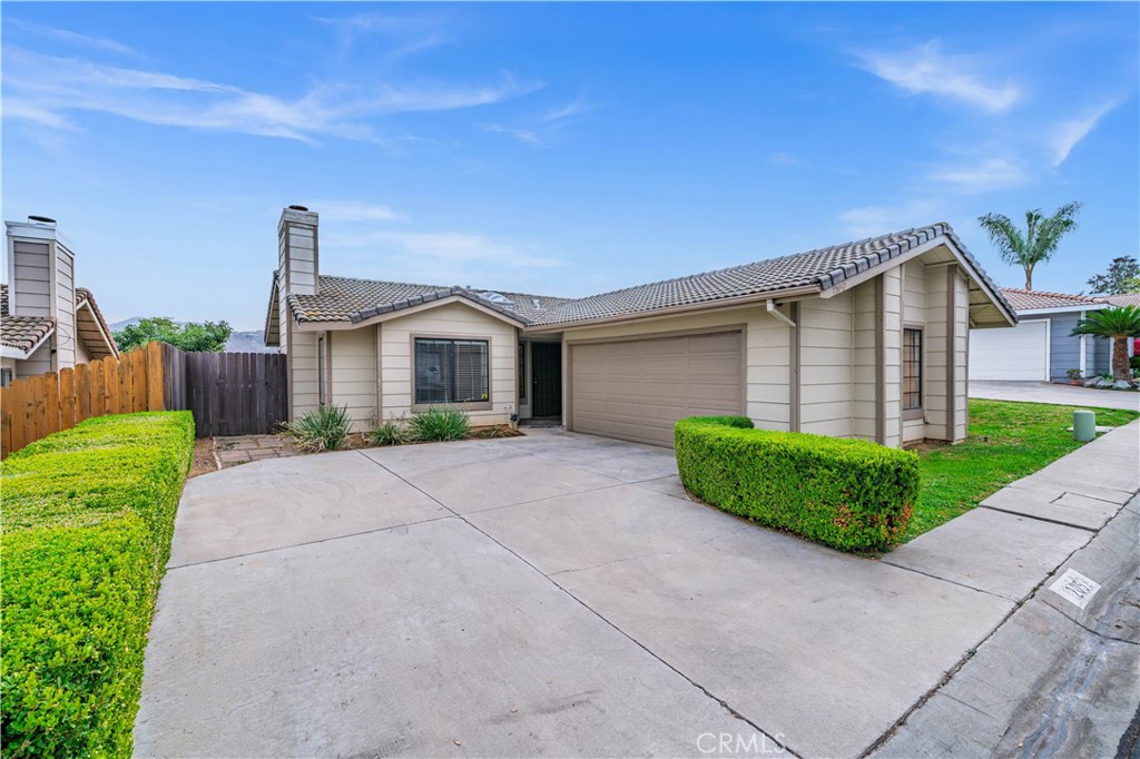 12052 Elk Boulevard Riverside, CA 92505 - Photo 1 of 25 a front view of a house with a yard and garage