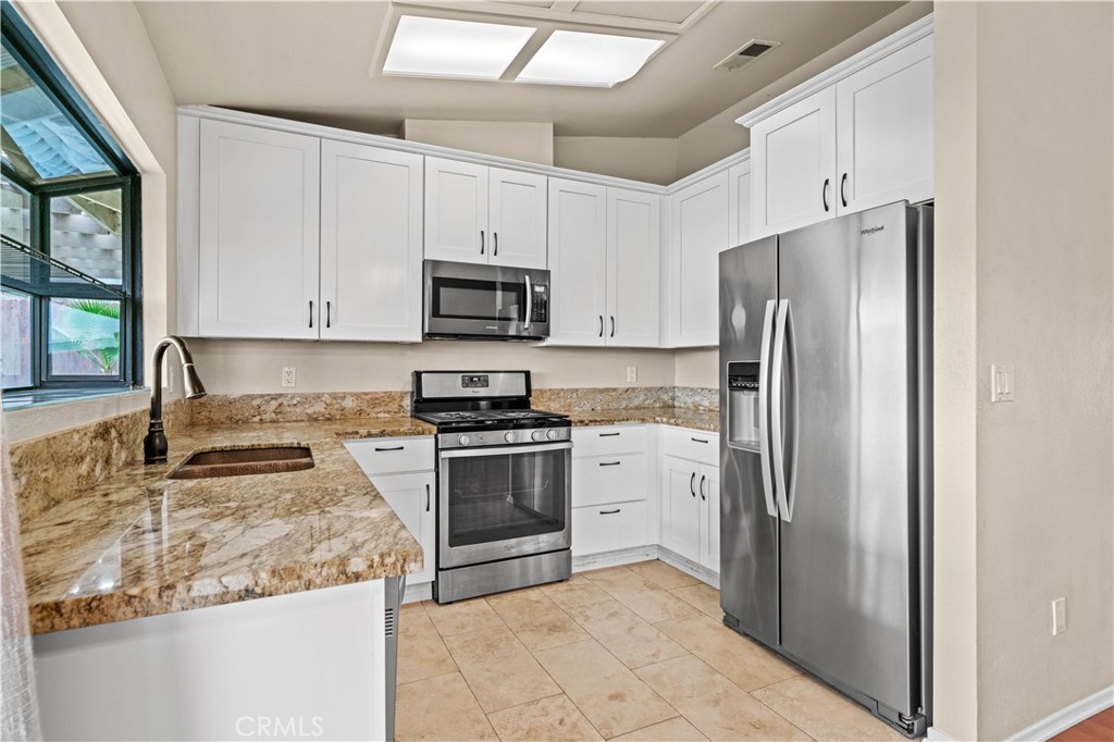 12052 Elk Boulevard Riverside, CA 92505 - Photo 7 of 25 a kitchen with stainless steel appliances granite countertop a refrigerator sink and stove