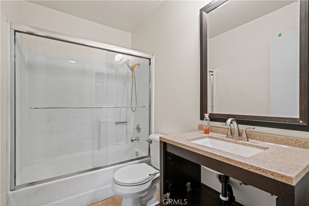 12052 Elk Boulevard Riverside, CA 92505 - Photo 10 of 25 a bathroom with a granite countertop sink toilet and shower