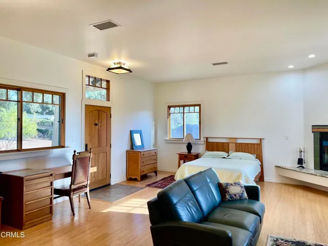 a bedroom with furniture and a large window