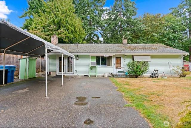a view of a house with backyard and sitting area