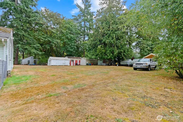a view of house with outdoor space and trees in the background