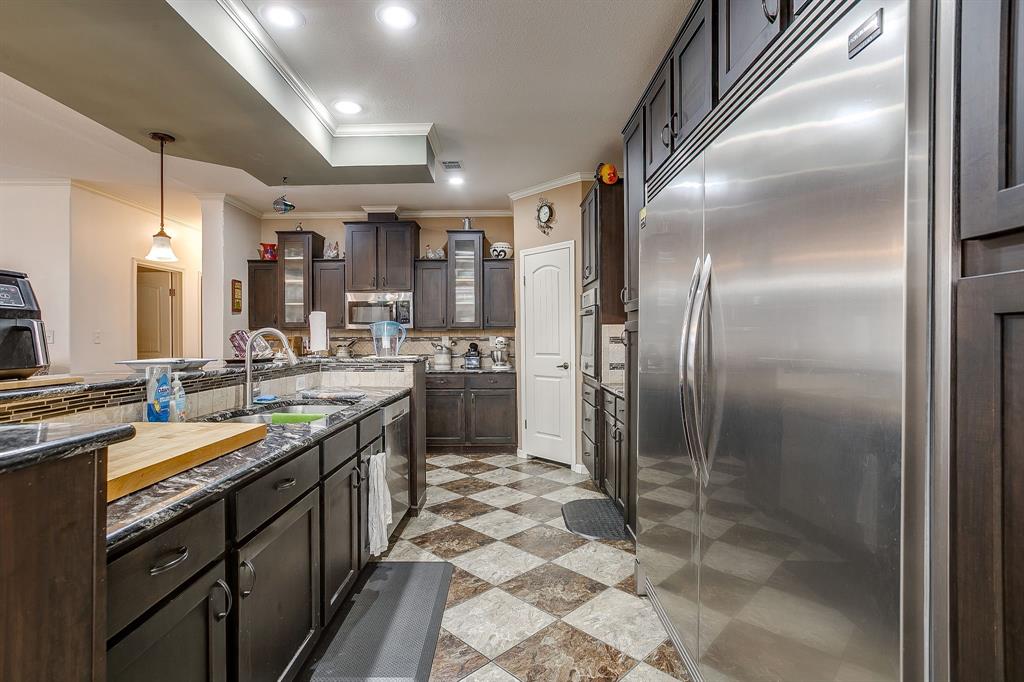 13740 County Road 4041 Scurry, TX 75158 - Photo 11 of 40 a kitchen with stainless steel appliances granite countertop a sink a stove and a refrigerator