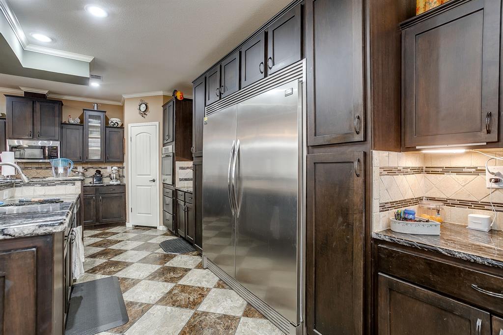 13740 County Road 4041 Scurry, TX 75158 - Photo 12 of 40 a kitchen with stainless steel appliances granite countertop a refrigerator and a stove top oven