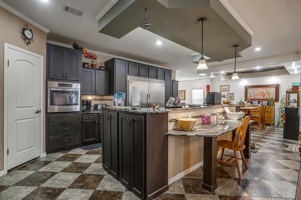 13740 County Road 4041 Scurry, TX 75158 - Photo 13 of 40 a kitchen with kitchen island a counter top space a refrigerator and cabinets