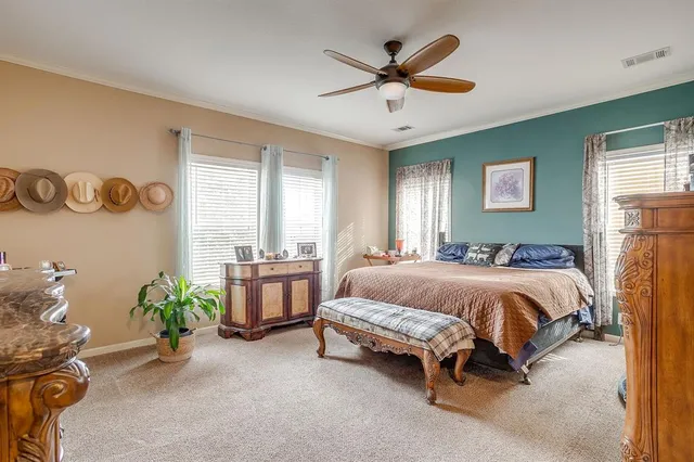 a spacious bedroom with a bed and a chandelier
