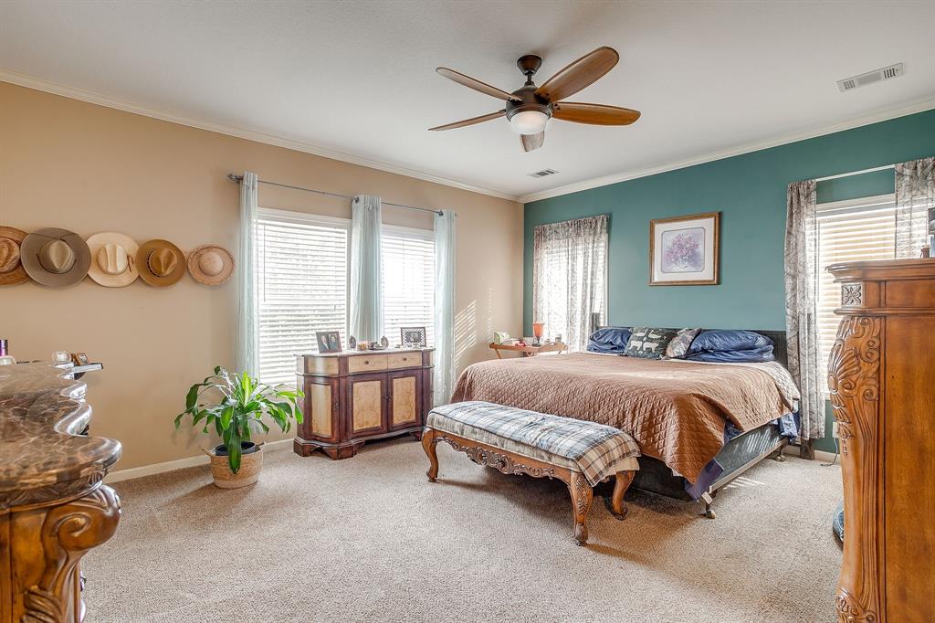 13740 County Road 4041 Scurry, TX 75158 - Photo 17 of 40 a spacious bedroom with a bed and a chandelier
