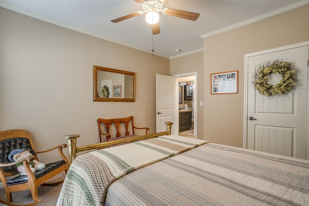 13740 County Road 4041 Scurry, TX 75158 - Photo 23 of 40 a bedroom with a bed and a chandelier