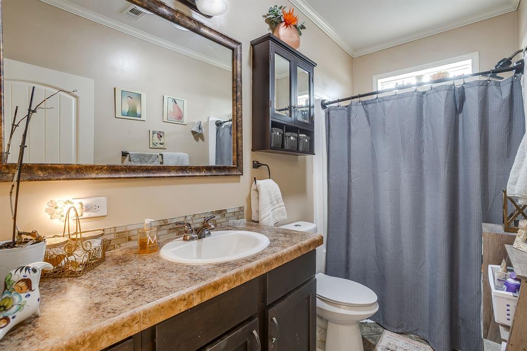 13740 County Road 4041 Scurry, TX 75158 - Photo 32 of 40 a bathroom with a granite countertop sink and a mirror