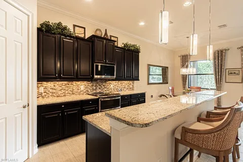 a large kitchen with granite countertop a sink and a refrigerator