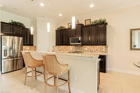 a kitchen with stainless steel appliances kitchen island granite countertop a refrigerator and a stove top oven