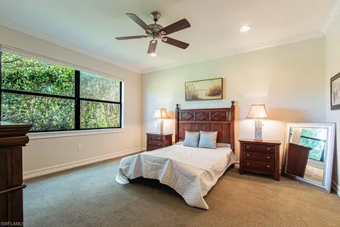 a bedroom with a bed and a large window