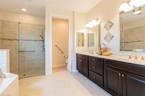 a spacious bathroom with a double vanity sink mirror and shower