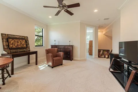 a living room with furniture a flat screen tv and a window
