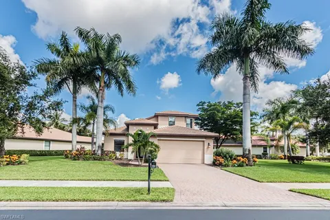 a front view of a house with a garden and tree