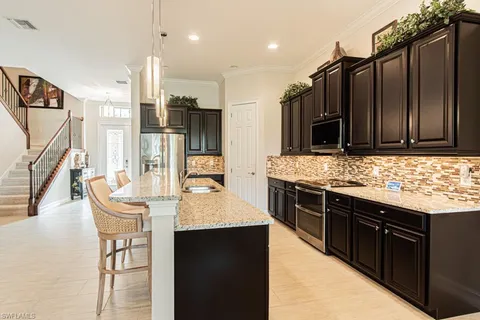 a open kitchen with stainless steel appliances granite countertop a stove and a sink
