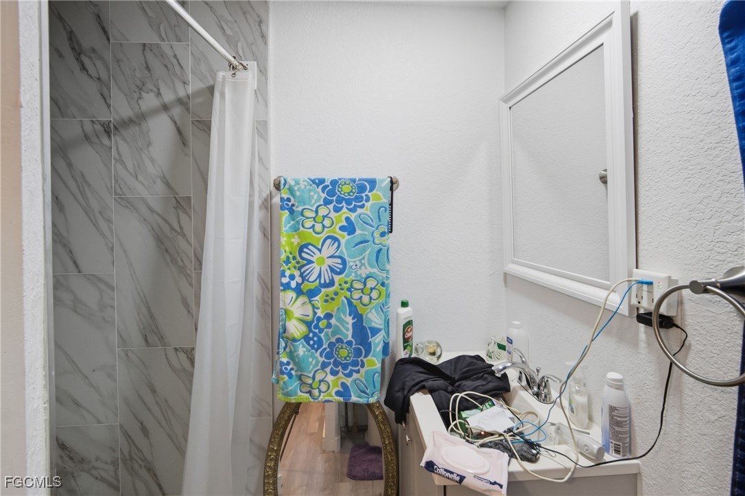 136 Lexington Avenue Fort Myers, FL 33908 - Photo 14 of 31 a bathroom with a sink and a shower curtain