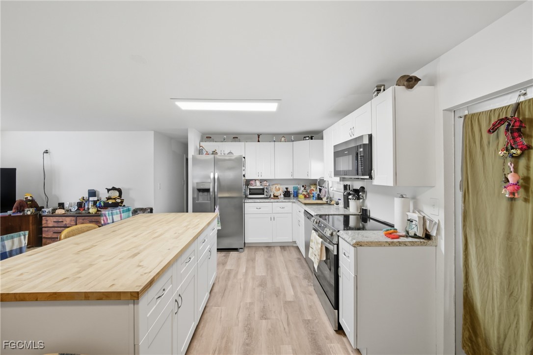 136 Lexington Avenue Fort Myers, FL 33908 - Photo 5 of 31 a large kitchen with a lot of counter space and wooden floor