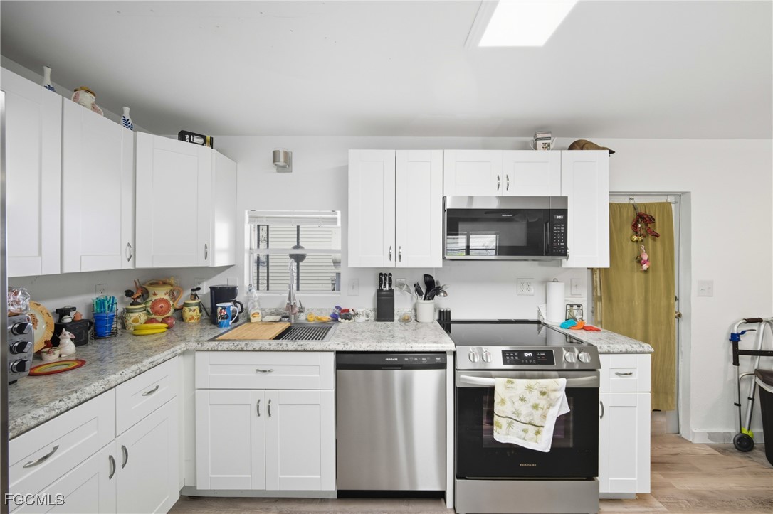 136 Lexington Avenue Fort Myers, FL 33908 - Photo 6 of 31 a kitchen with stainless steel appliances granite countertop a stove a sink and a refrigerator