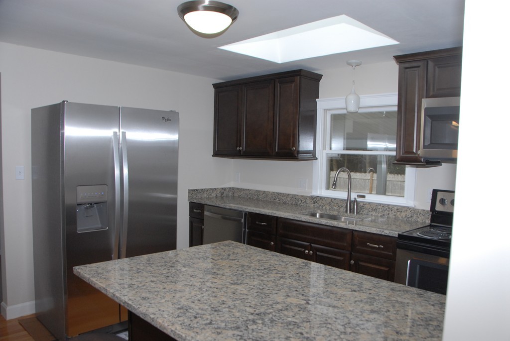 17 Margaret Road Hamilton, MA 01982 - Photo 4 of 24 a kitchen with stainless steel appliances granite countertop a sink and a refrigerator