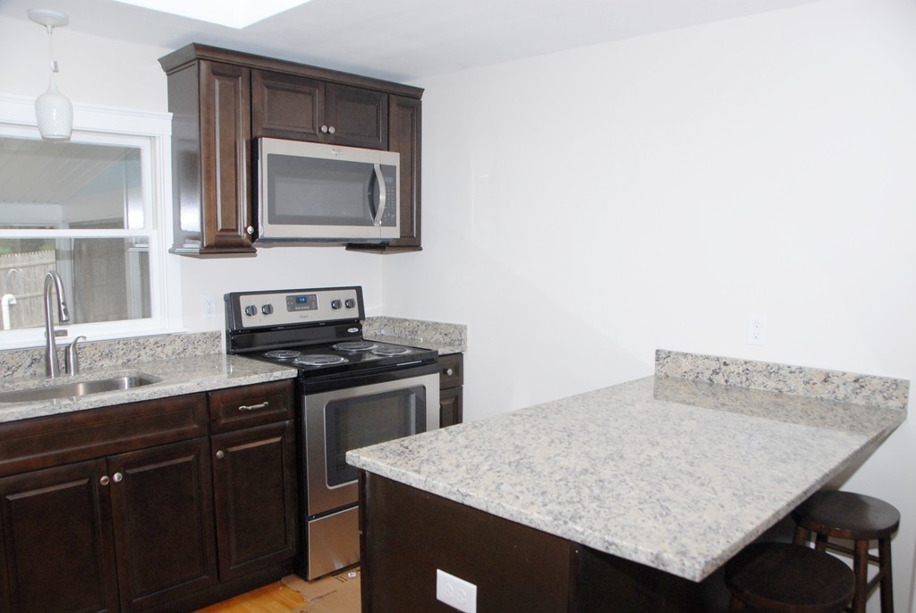 17 Margaret Road Hamilton, MA 01982 - Photo 7 of 24 a kitchen with stainless steel appliances granite countertop a sink and a stove