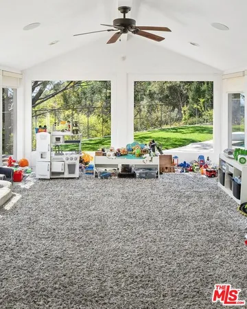 a view of a room with furniture and large windows