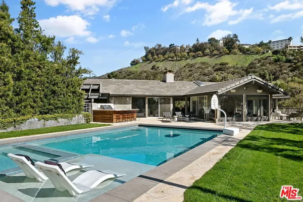 a view of a house with swimming pool and sitting area