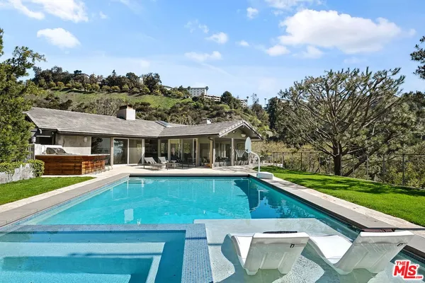 a view of a swimming pool with lawn chairs and a yard