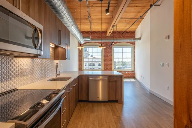 a kitchen with stainless steel appliances granite countertop a sink stove and wooden floor