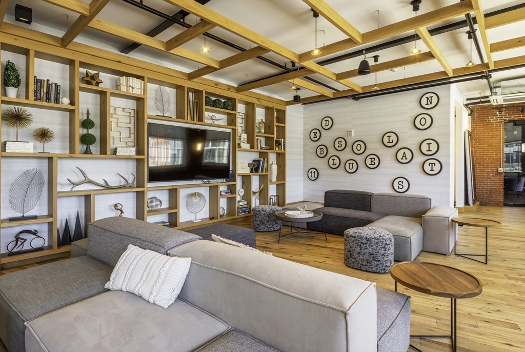 165 Thorndike Street, Unit 403 Lowell, MA 01852 - Photo 7 of 10 a living room with furniture and a flat screen tv