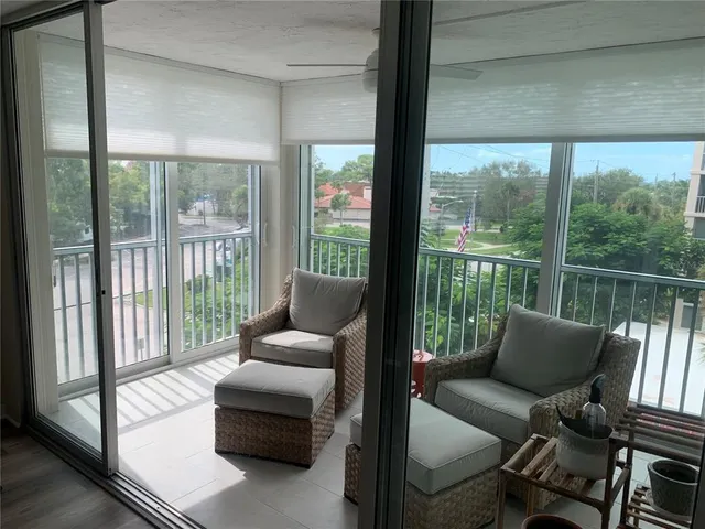 a balcony with furniture and a floor to ceiling window