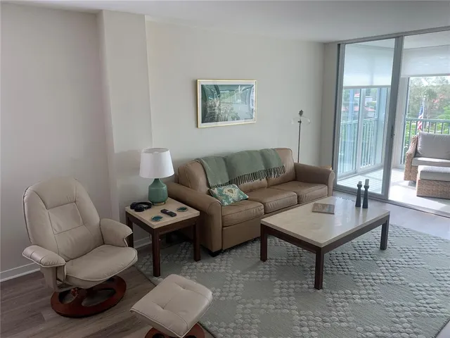 a living room with furniture and a floor to ceiling window