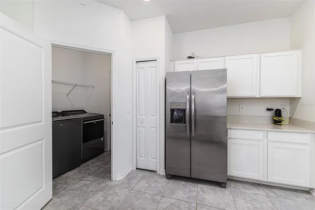 a kitchen with a refrigerator sink and cabinets