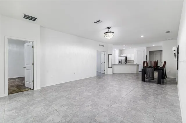 a living room with furniture and a refrigerator