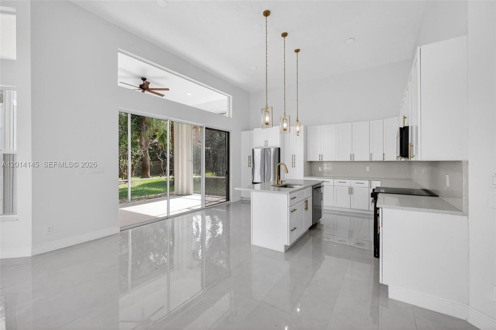 19558 Red Gum Trail Jupiter, FL 33458 - Photo 24 of 81 a large kitchen with kitchen island a large window a island and stainless steel appliances