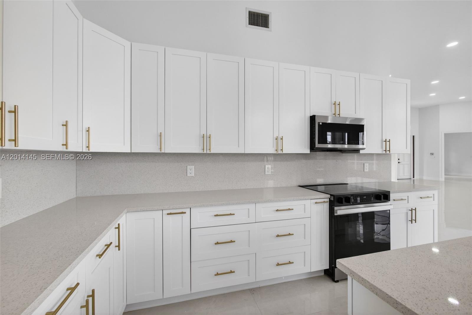 19558 Red Gum Trail Jupiter, FL 33458 - Photo 28 of 81 a kitchen with white cabinets and a stove