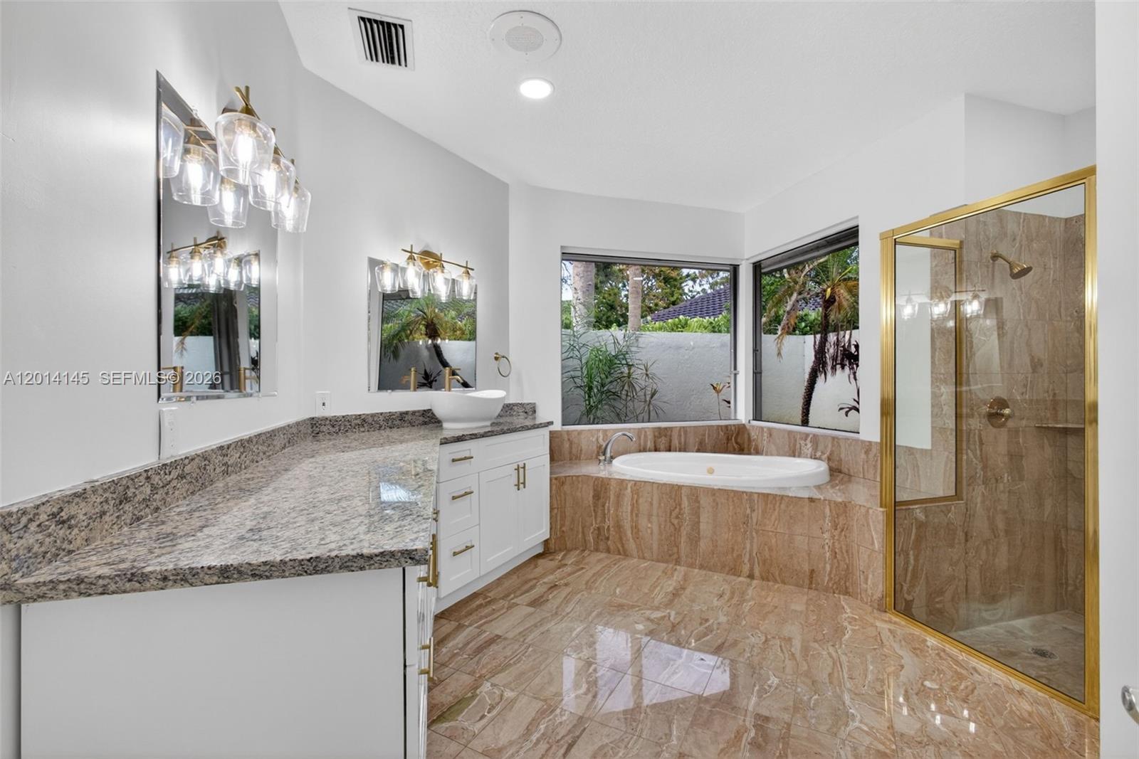 19558 Red Gum Trail Jupiter, FL 33458 - Photo 38 of 81 a spacious bathroom with a granite countertop tub sink and mirror