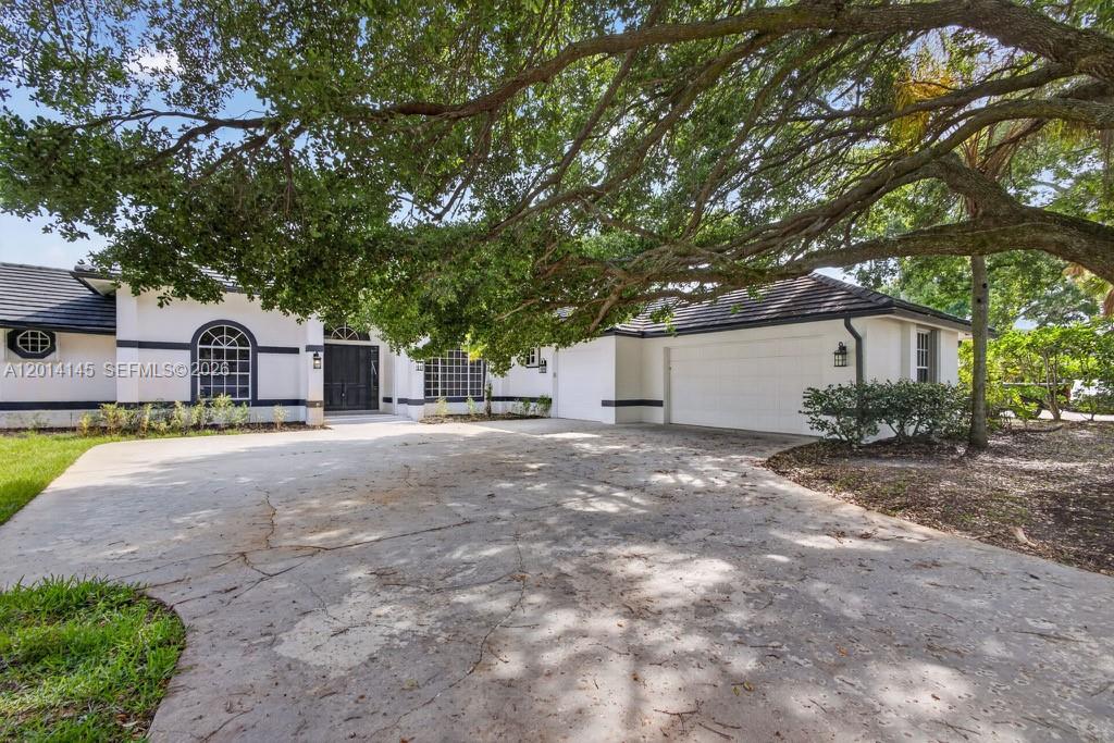 19558 Red Gum Trail Jupiter, FL 33458 - Photo 6 of 81 a view of a house with a yard and large tree