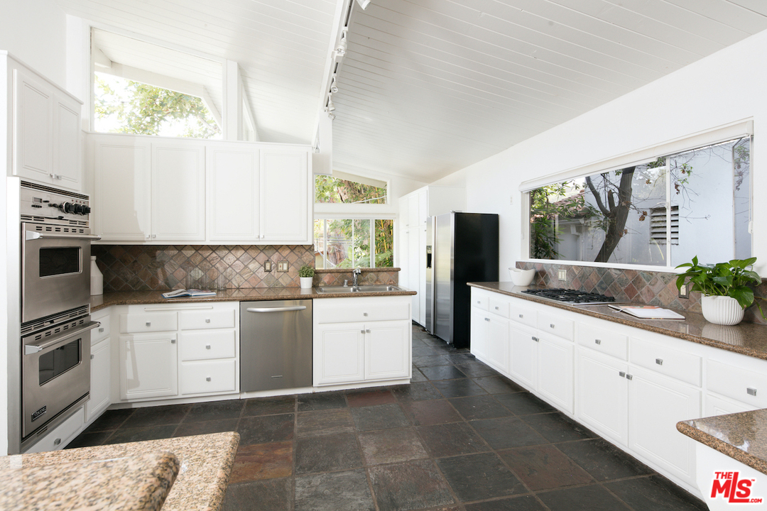 348 Sycamore Road Santa Monica, CA 90402 - Photo 5 of 12 a kitchen with granite countertop white cabinets a sink a window and stainless steel appliances
