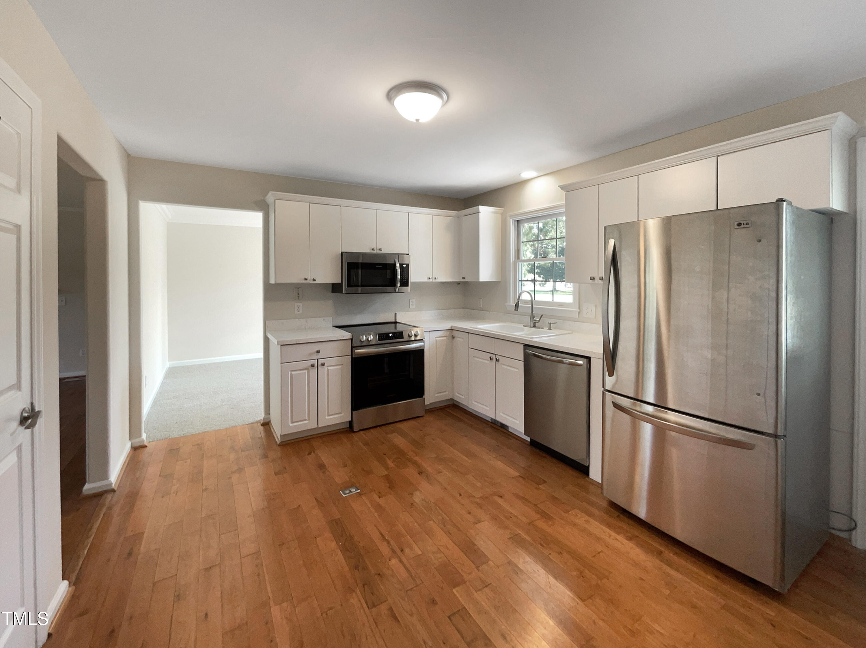 27 Pine Croft Road Angier, NC 27501 - Photo 7 of 19 a kitchen with a refrigerator a stove top oven and a hard wood floor