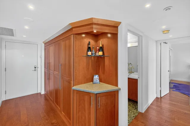 a room with stainless steel appliances kitchen island granite countertop a stove and white cabinets